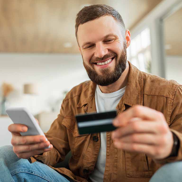 Man With Phone And Card Paying